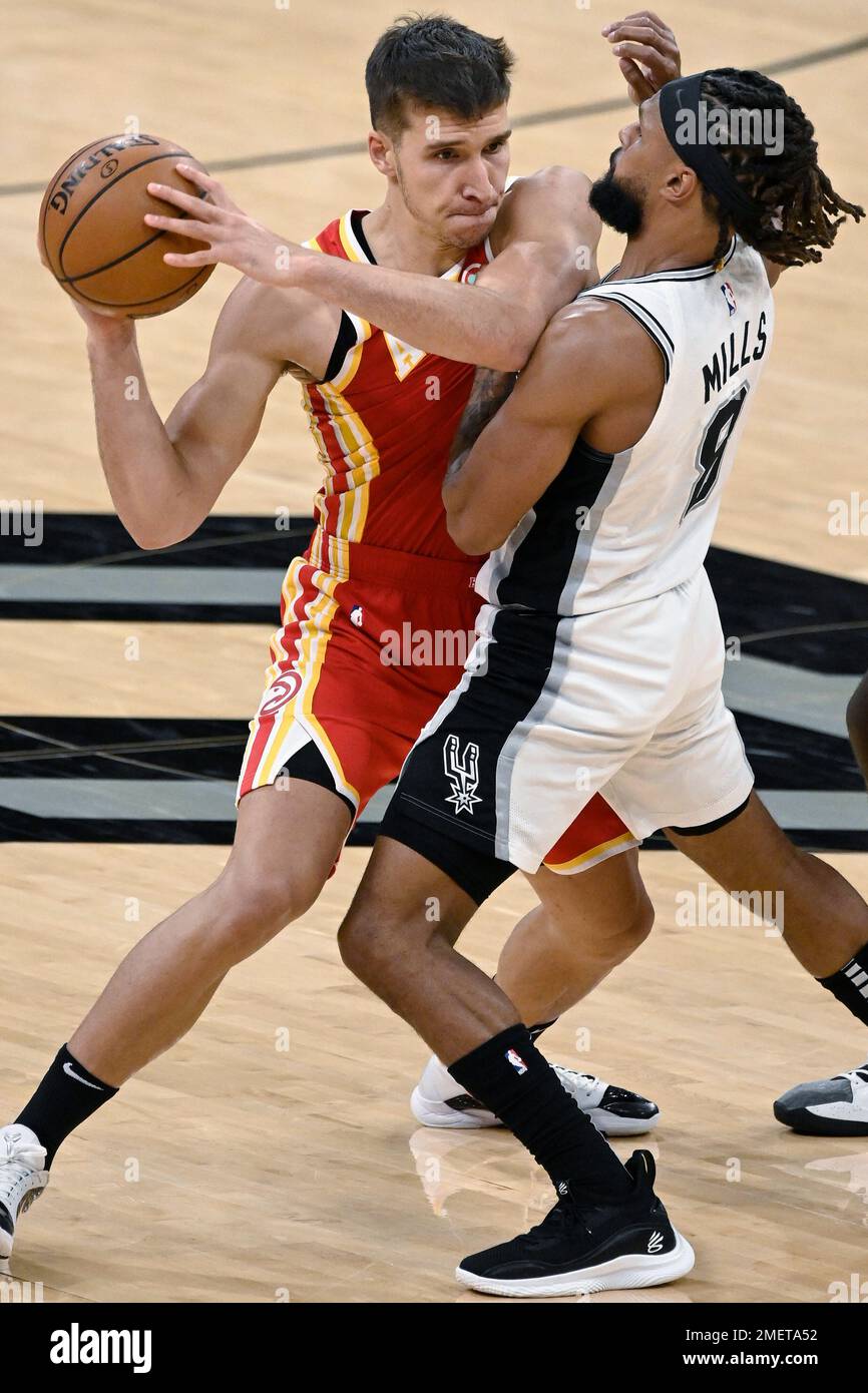 Atlanta Hawks' Trae Young (11) collides with San Antonio Spurs' Patty Mills  during the second half of an NBA basketball game, Thursday, April 1, 2021,  in San Antonio. (AP Photo/Darren Abate Stock