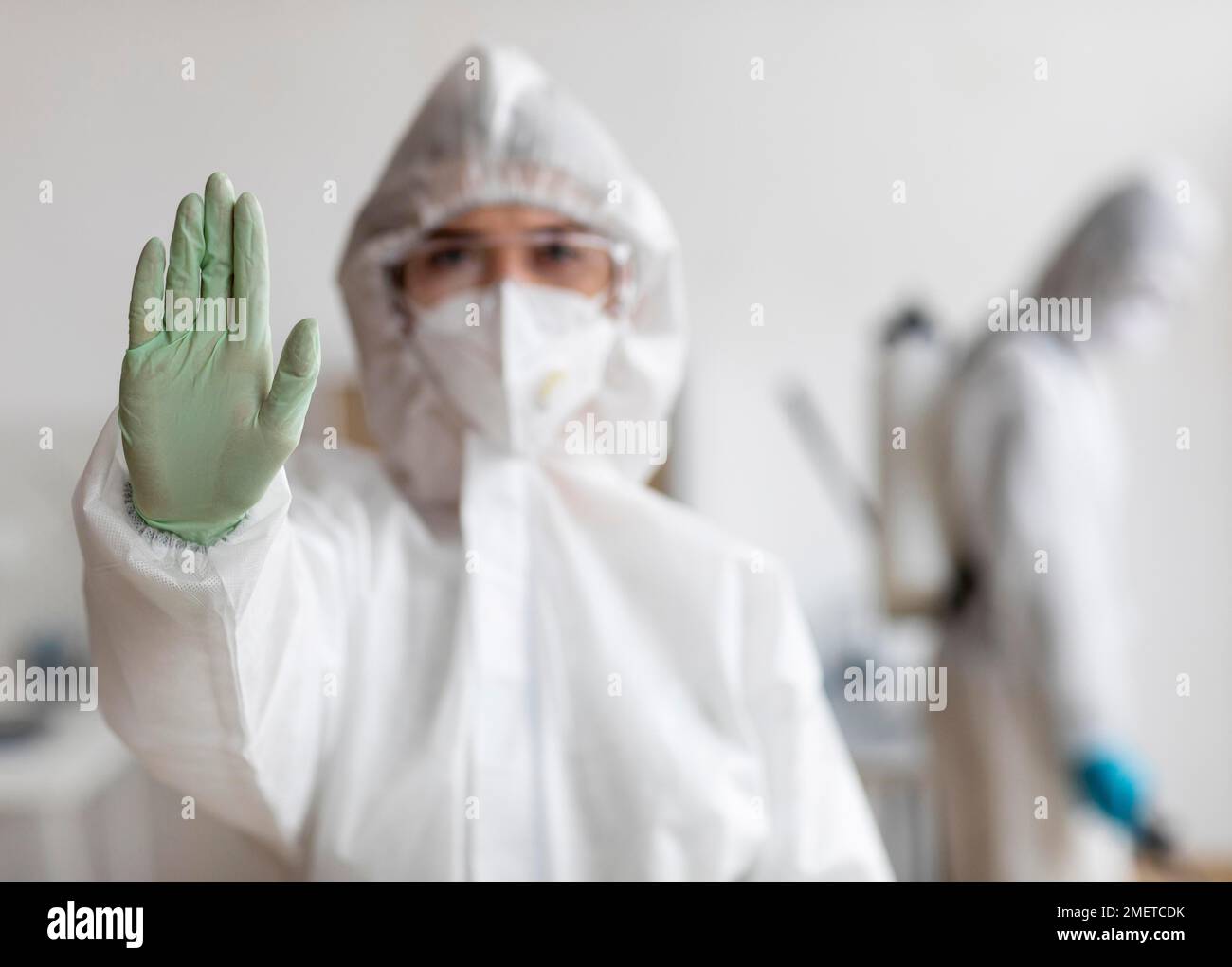 People wearing protective equipment disinfecting dangerous area Stock Photo