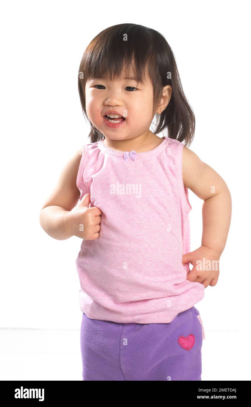 Girl wearing pink vest and purple jogging pants, 20 months Stock Photo
