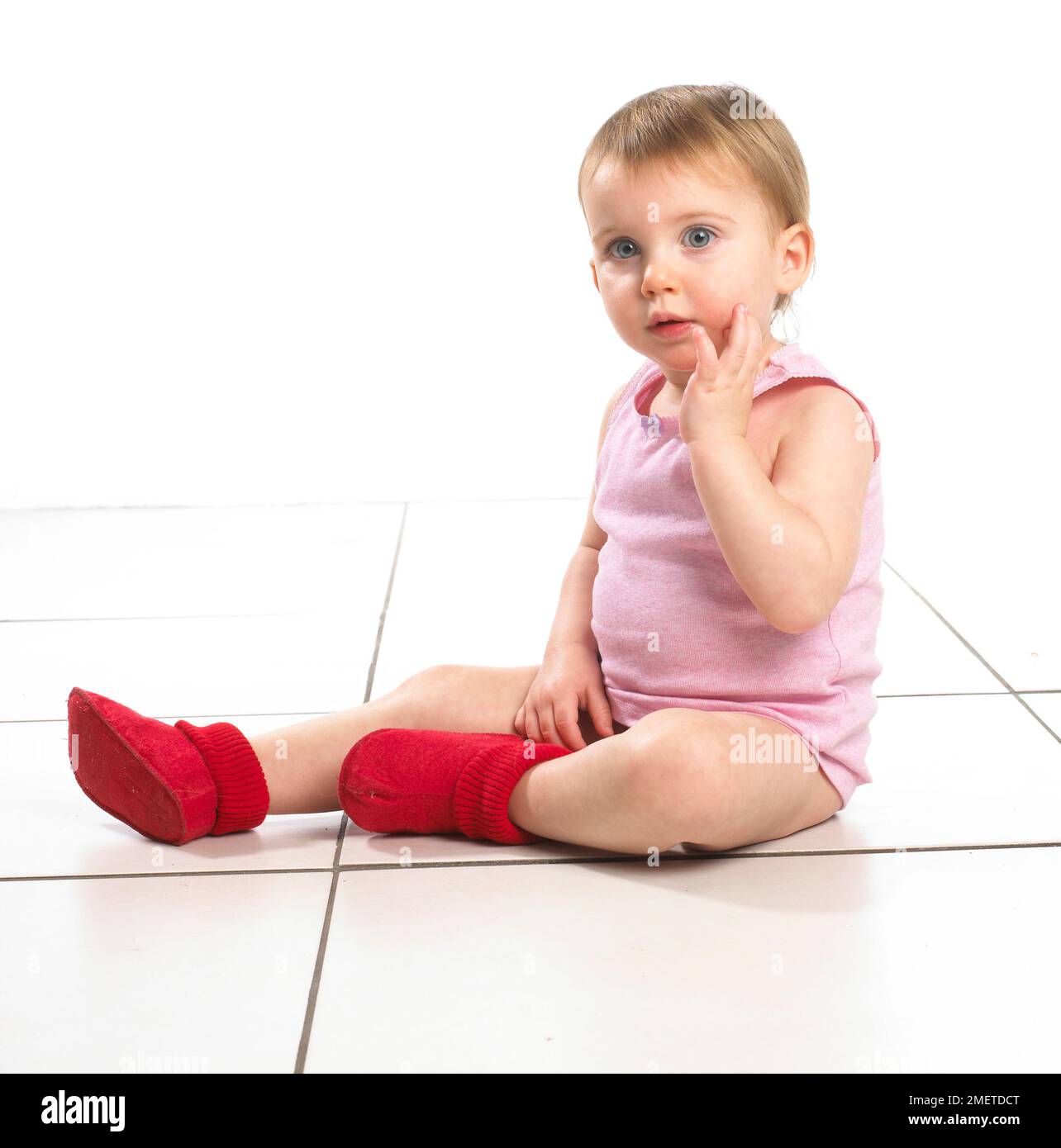 Girl, sitting, wearing red socks and pink top, 19 months Stock Photo