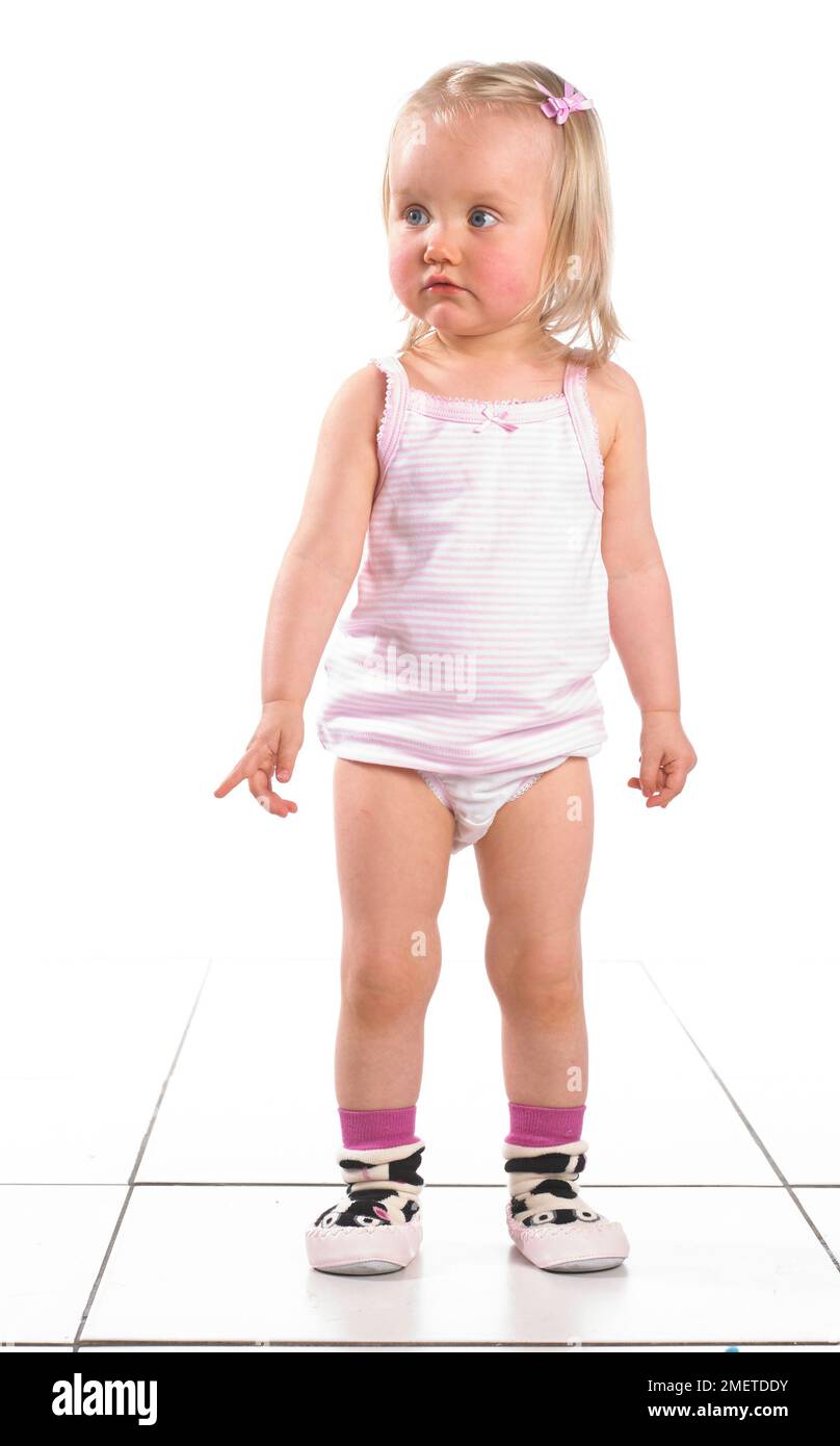 Girl wearing vest, pants and slippers, 20 months Stock Photo