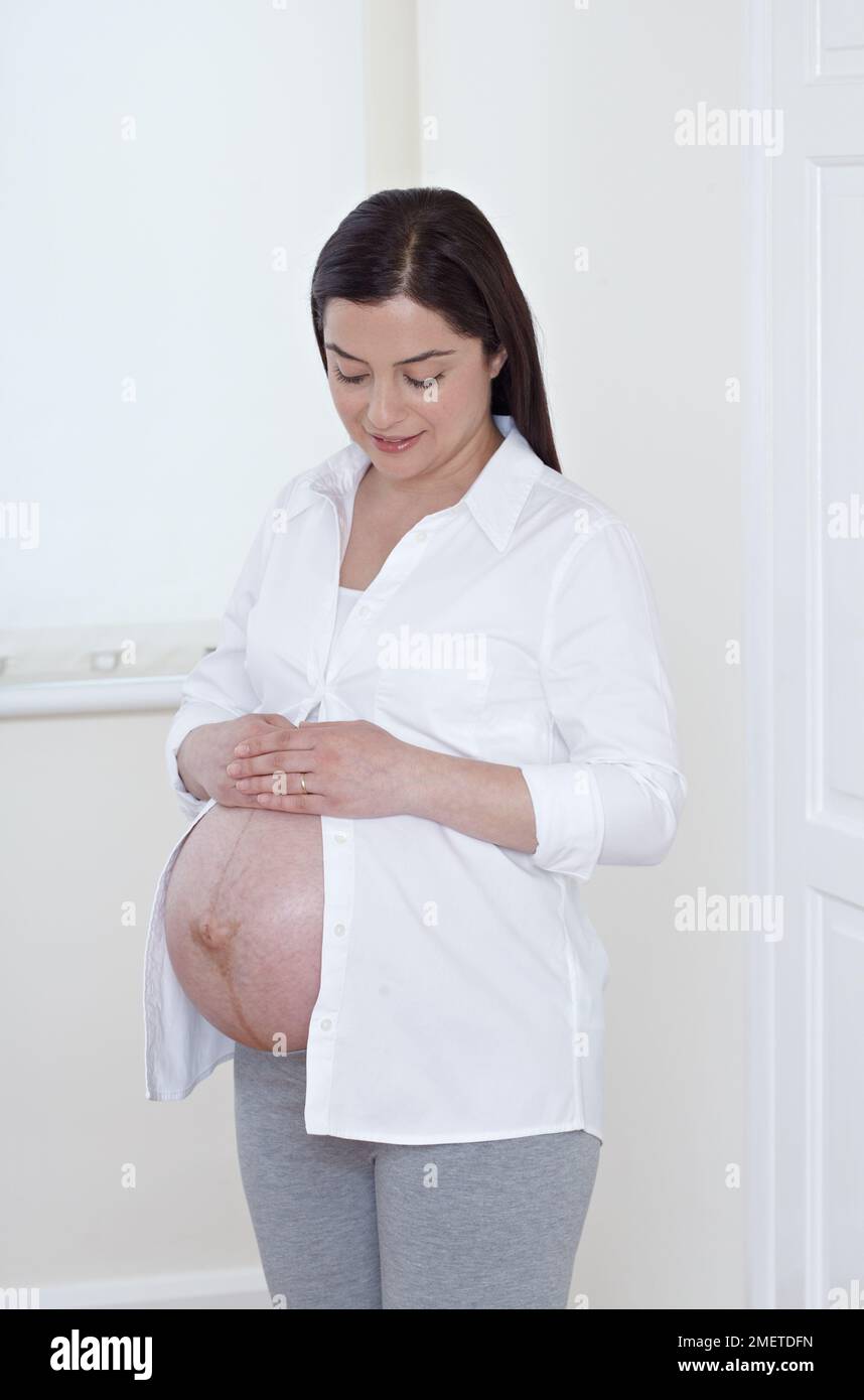 Heavily pregnant woman with her belly exposed Stock Photo - Alamy
