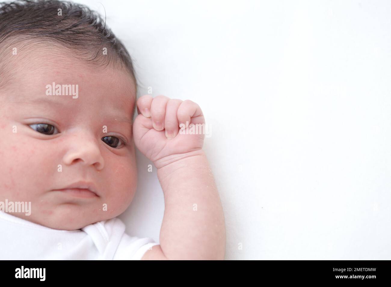 Baby girl's face and hand, making fist Stock Photo