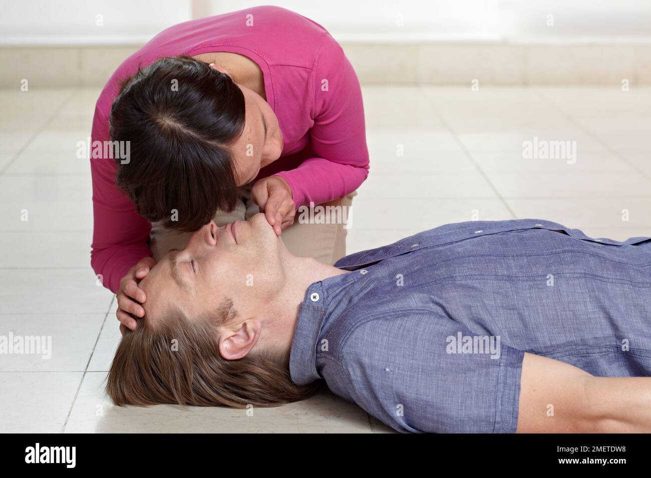 First aid treatment, giving CPR, checking breathing, supporting head of casualty Stock Photo Alamy