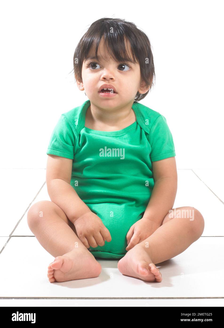 Baby boy (16 months) sitting on the floor Stock Photo