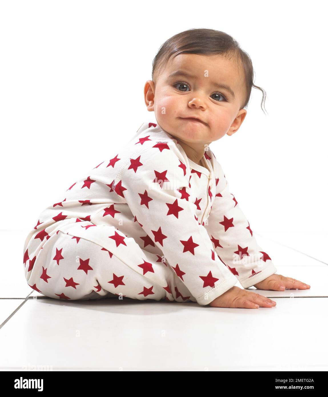 Baby girl sitting wearing onesie, 7 months Stock Photo Alamy