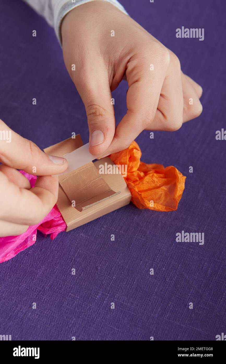Child performing Magic Newspaper trick, preparing the cardboard sleeve ...