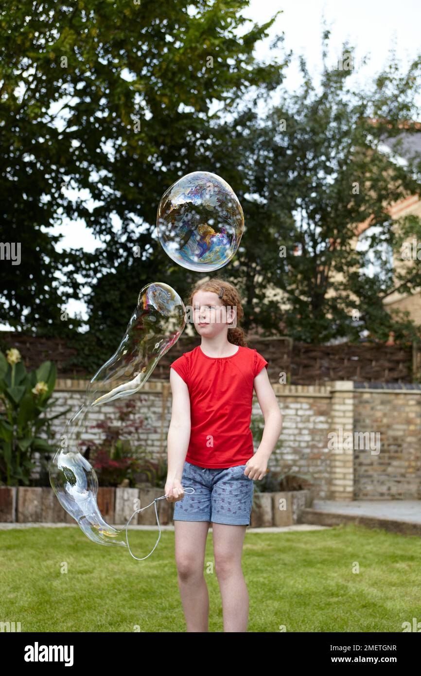 Making bubbles using wire clothes hanger as bubble wand Stock Photo Alamy