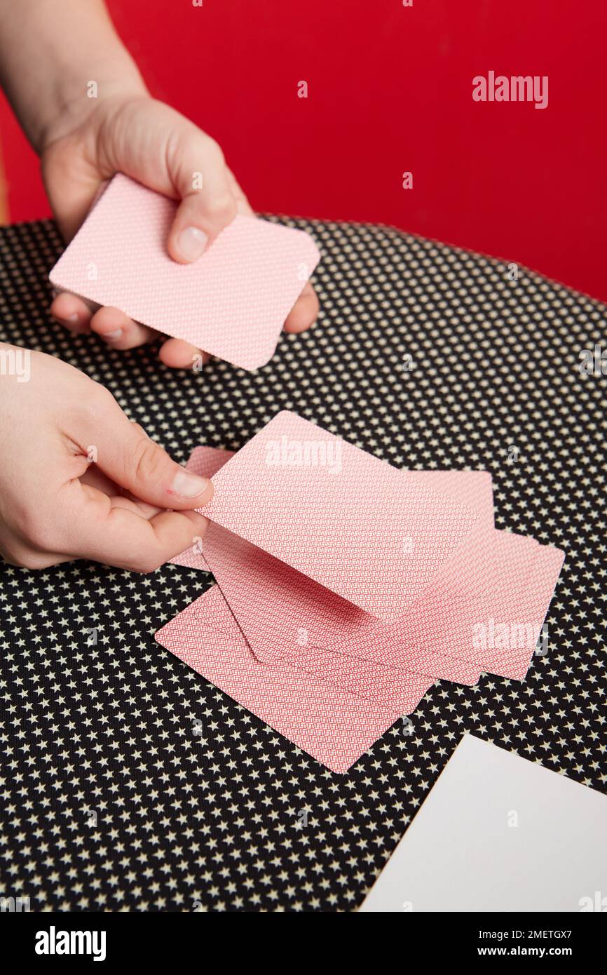 Performing card trick, Card Prediction, dealing cards in a rough pile Stock Photo