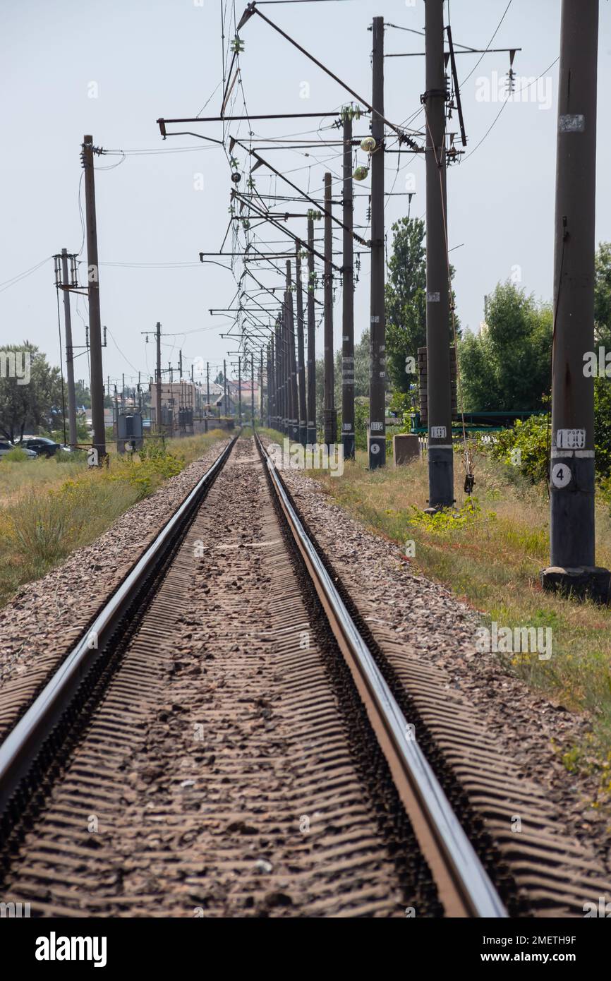 Railway track in a green forest. Cloudy weather and rain. Railroad