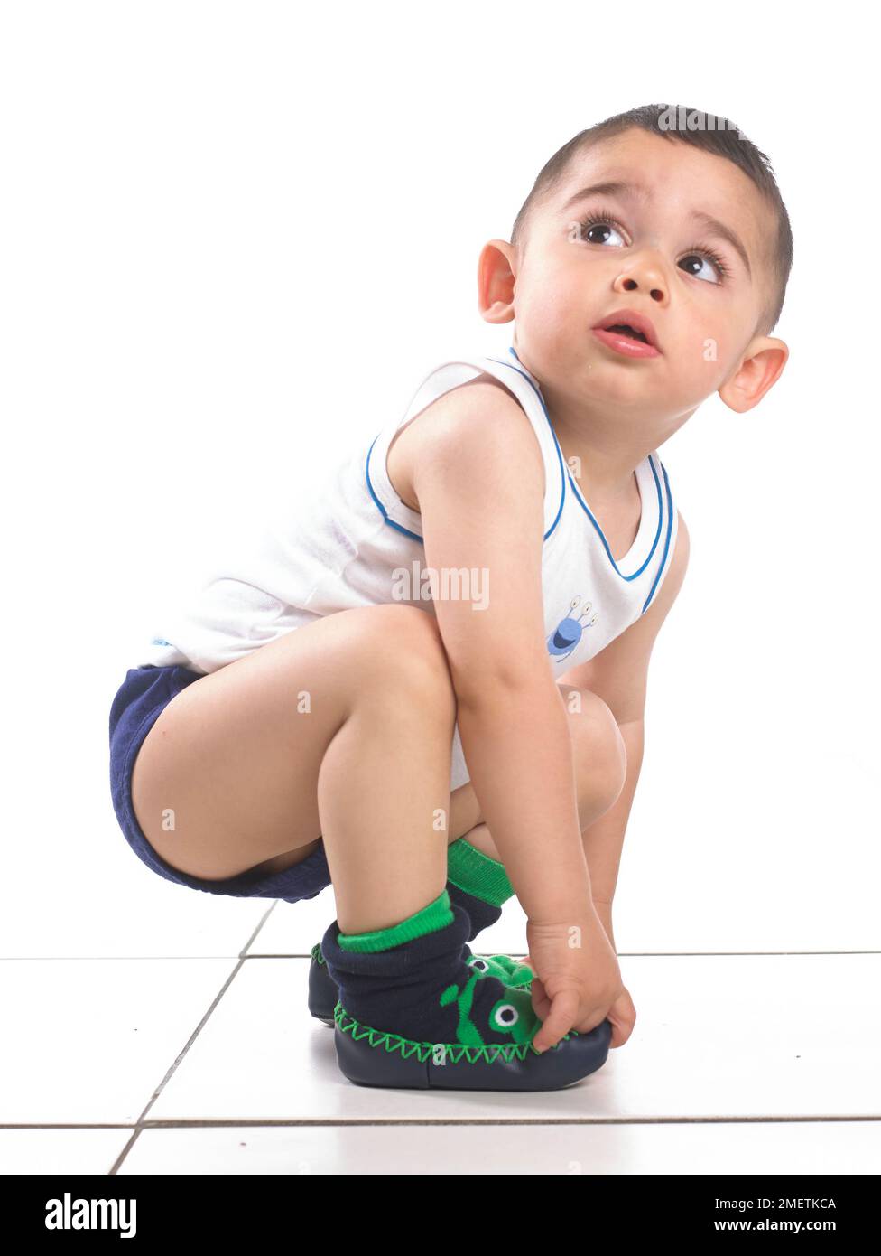 Boy wearing vest, pants and slippers, 15 months Stock Photo