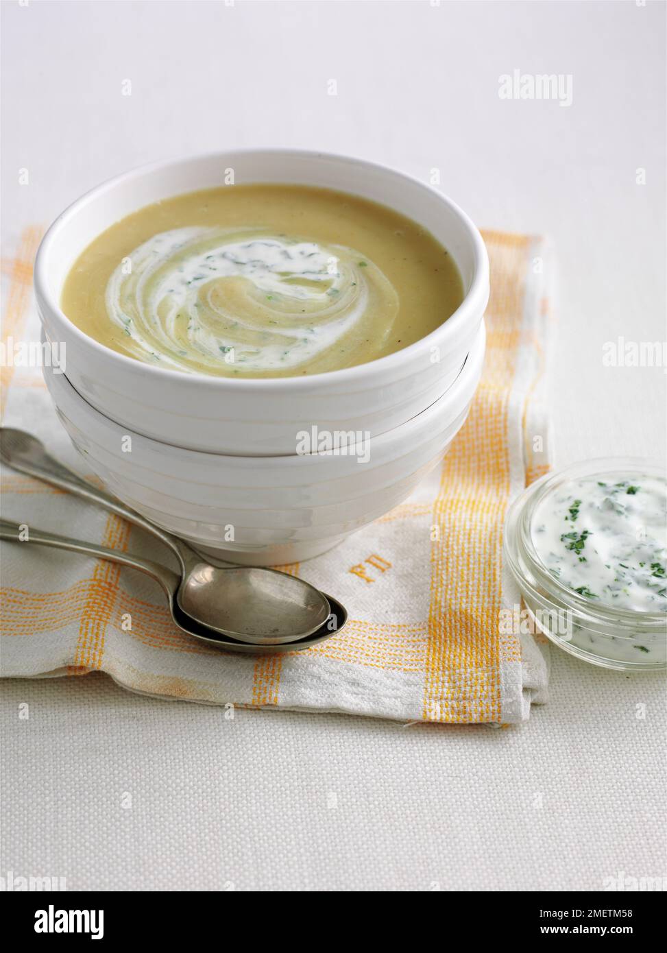 Bowl of curried parsnip soup topped with coriander yoghurt Stock Photo