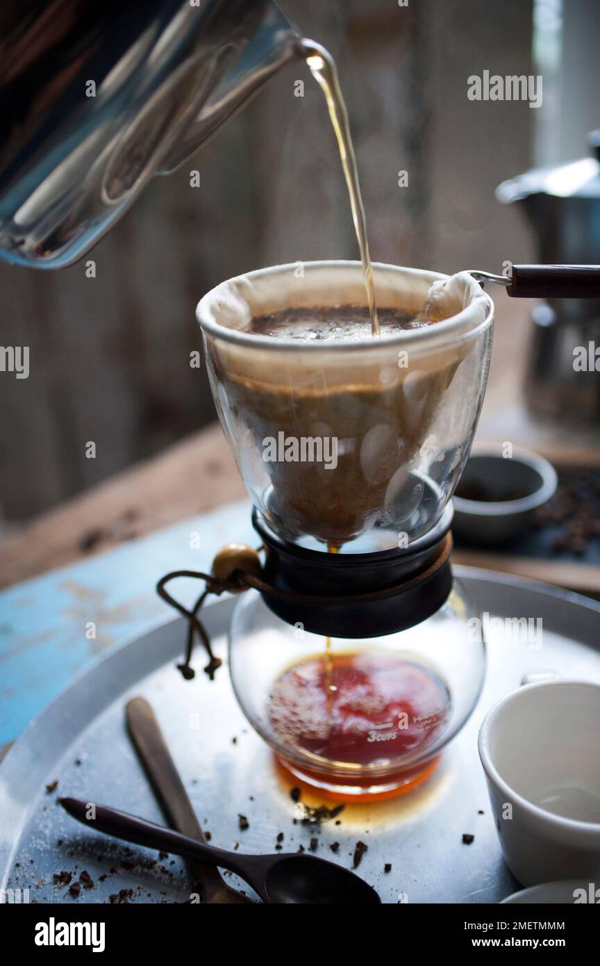 Caffe Touba, pouring hot water into coffee draining through a cloth