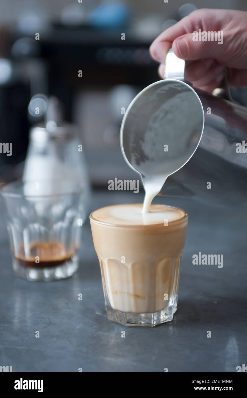 Breve, pouring steamed milk and cream over an espresso shot Stock Photo
