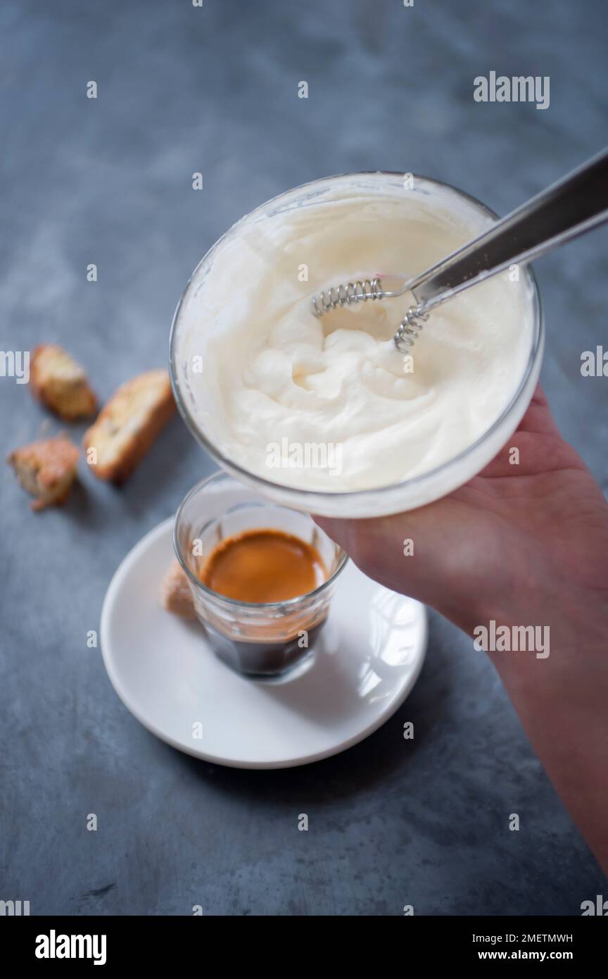 Adding whipped cream to an espresso shot Stock Photo Alamy