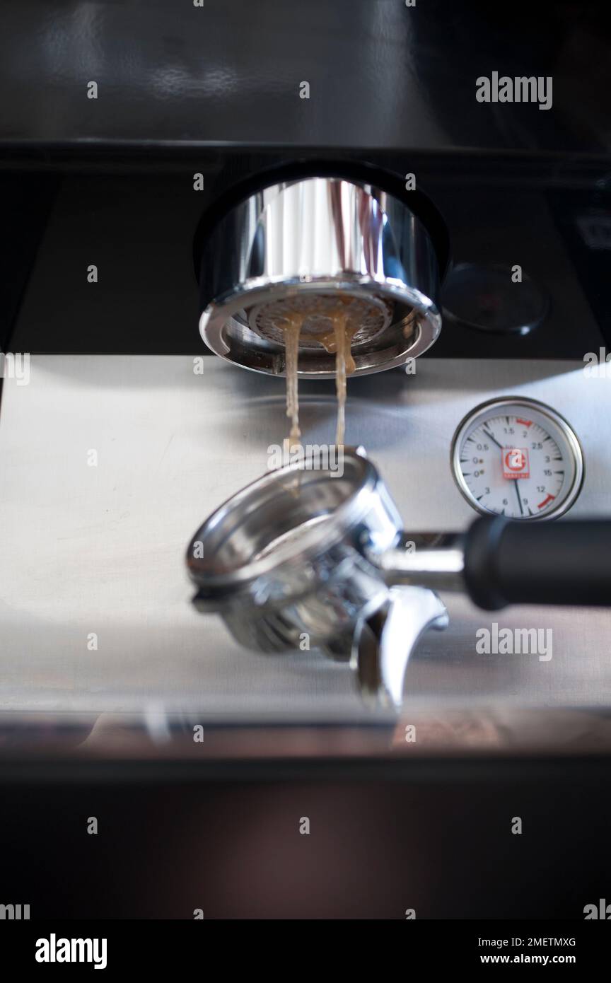 Cleaning espresso machine, flushing group head with water Stock Photo