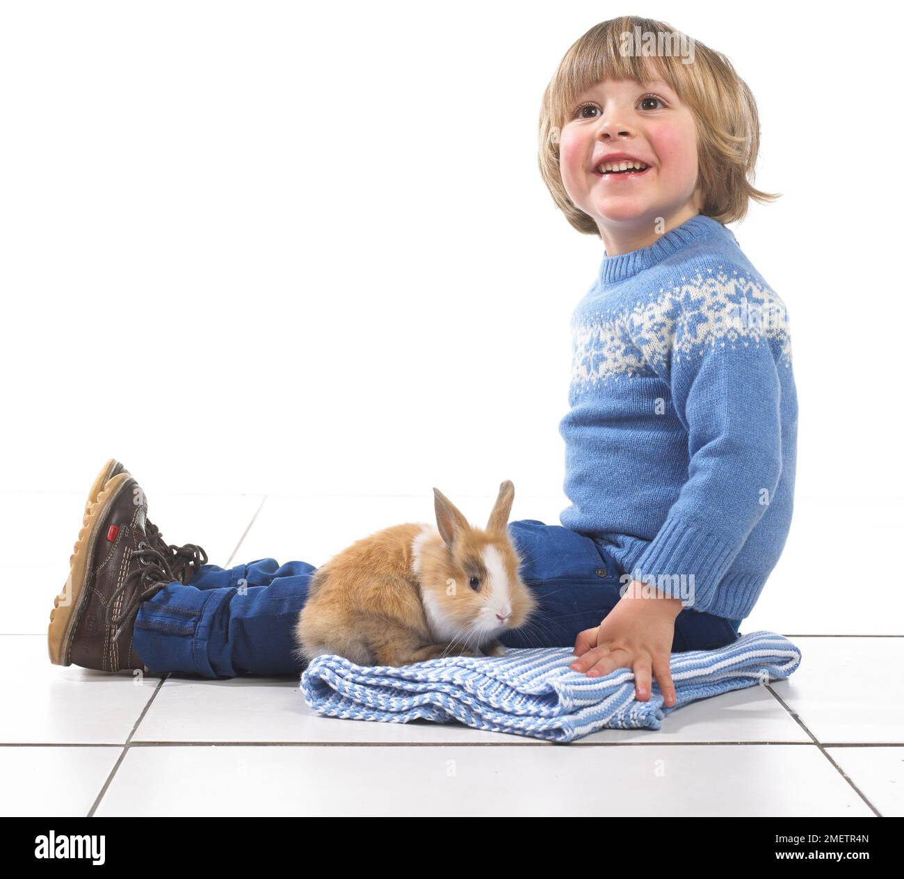 Boy sitting with rabbit on blanket, 3 years Stock Photo - Alamy