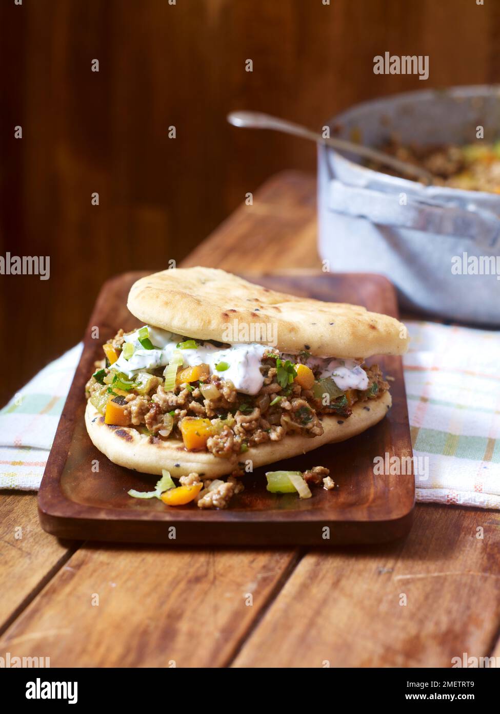 Curried lamb sloppy joes with naan bread and herby yoghurt Stock Photo