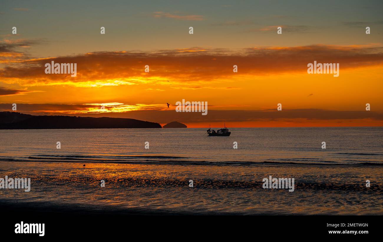 Ayr winter sunset with fishing boat in the bay Stock Photo