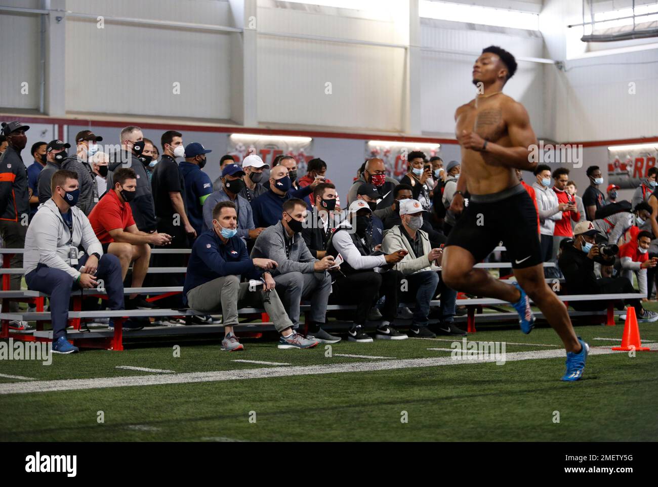 Scouts and coaches watch Justin Fields run the 40 yard dash during an
