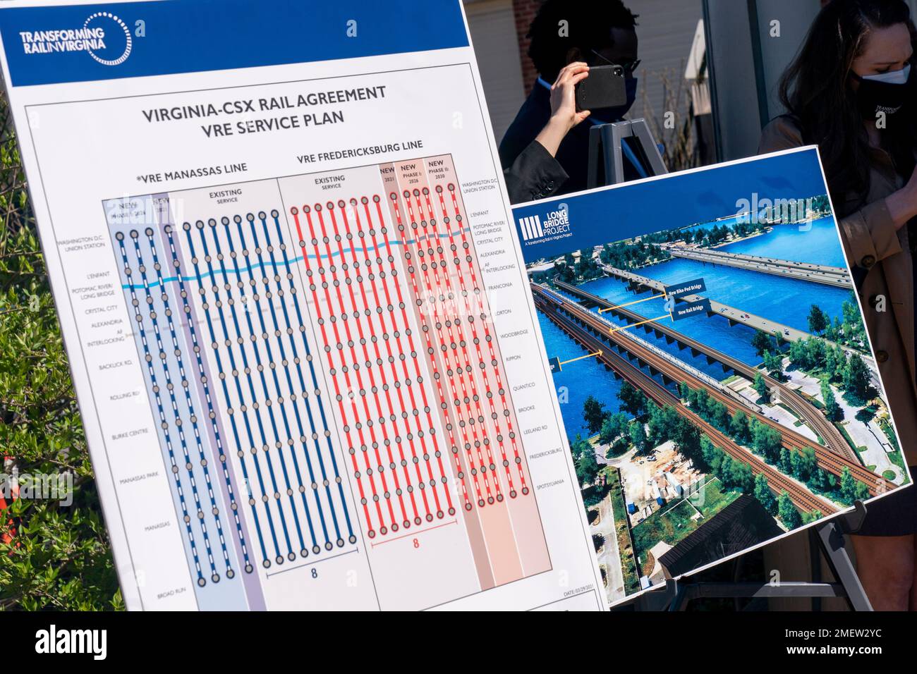 Posters depicting transportation plans are on display at a news