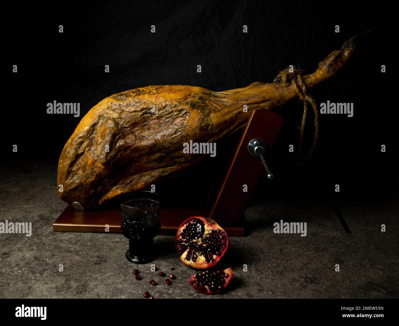 leg of jamon whole with pomegranate and wine on a black background Stock Photo
