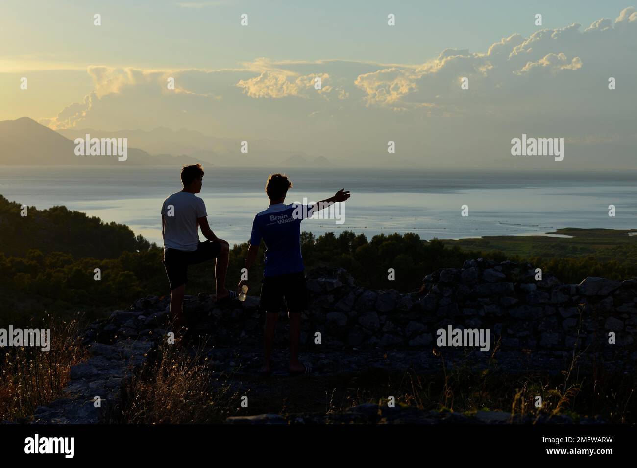 Two young men looking at Lake Scutari, also Lake Shkodra in the sunset, Shkodra, Shkoder, Albania Stock Photo