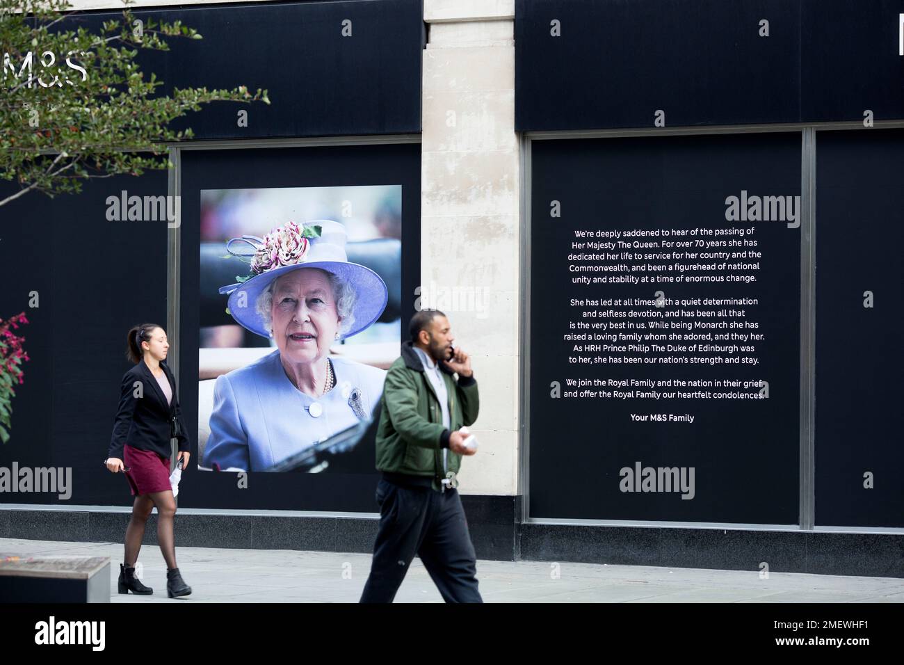 A Pedestrian Walks Past A Portrait Of Queen Elizabeth Ii Displayed On