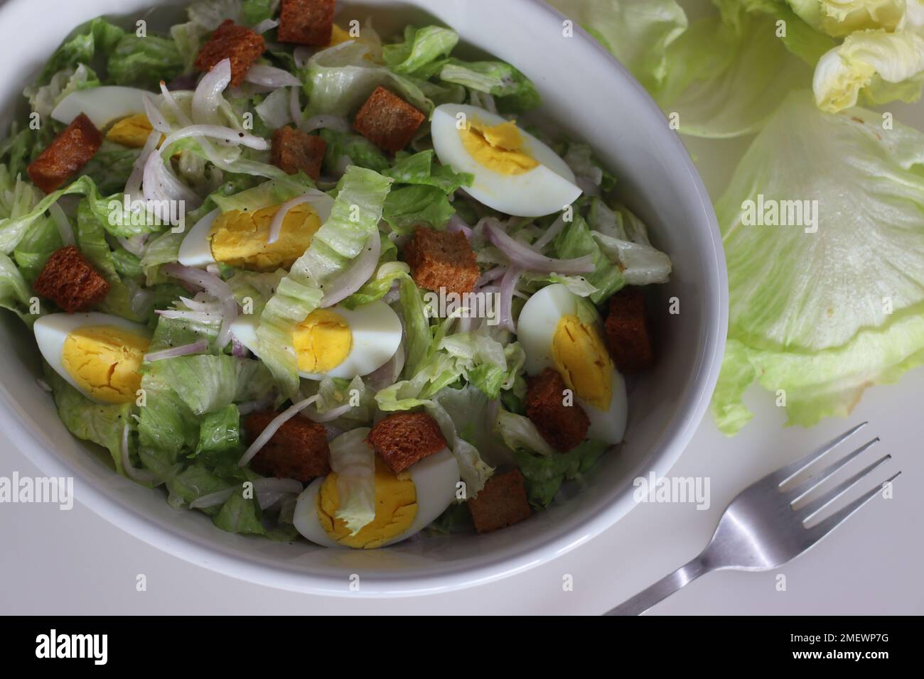 Lettuce salad with boiled egg. Easy salad with iceberg lettuce, onions