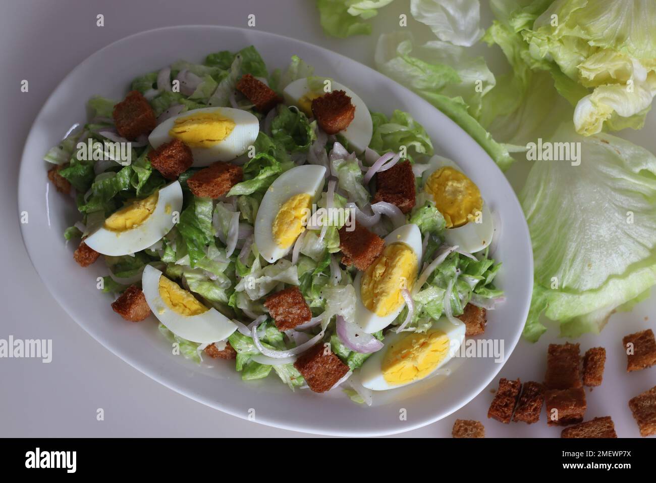 Lettuce salad with boiled egg. Easy salad with iceberg lettuce, onions