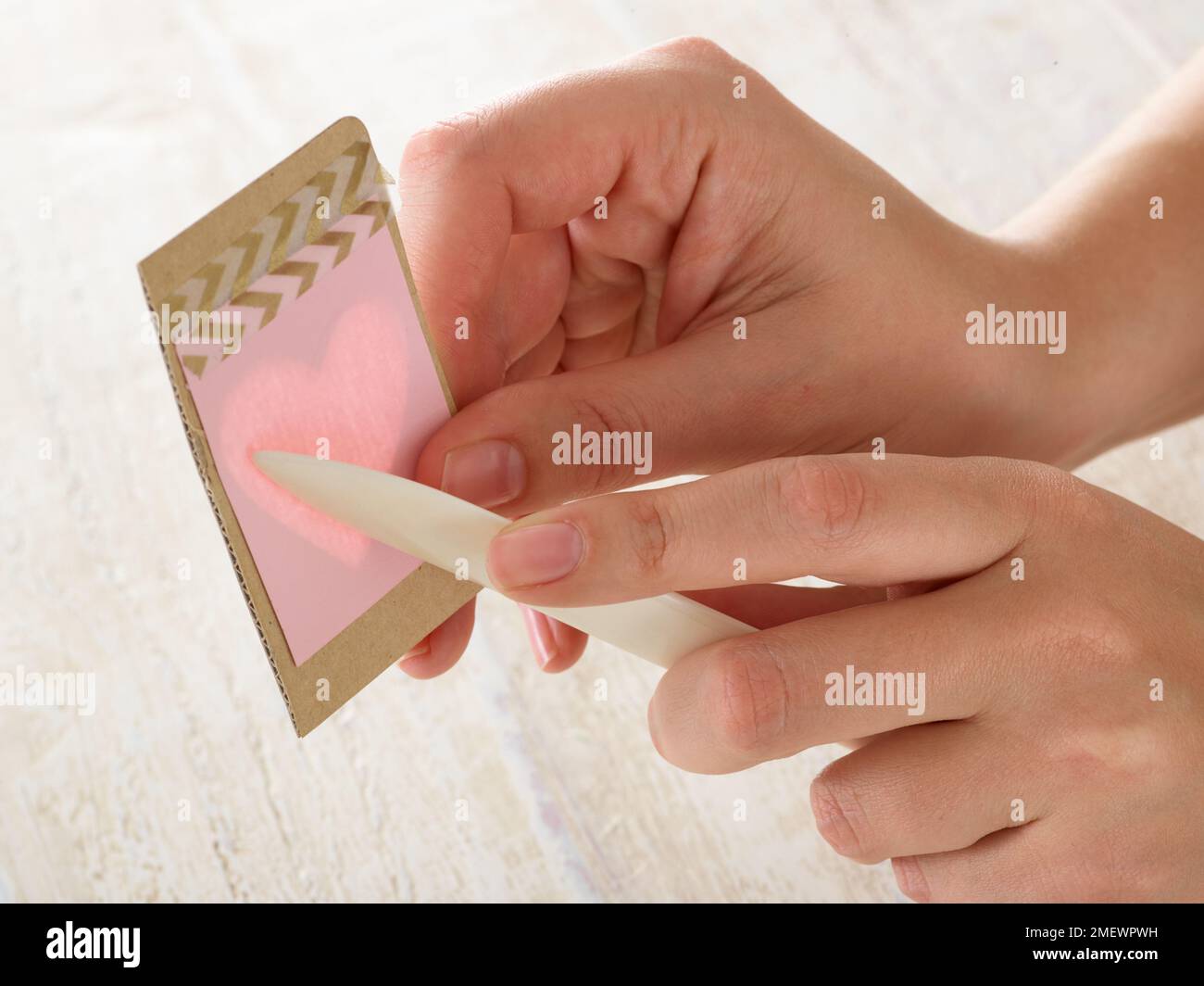 Papercraft. DIY paper embossing step 2. Place card over stencil and