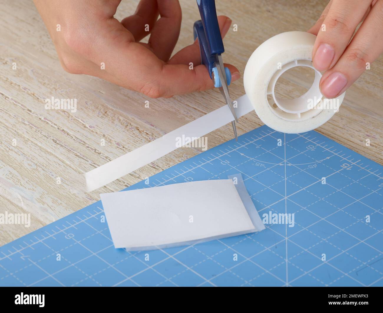 Papercraft. DIY photo frames, Step 2. Add strips of tape to edges of photo Stock Photo Alamy