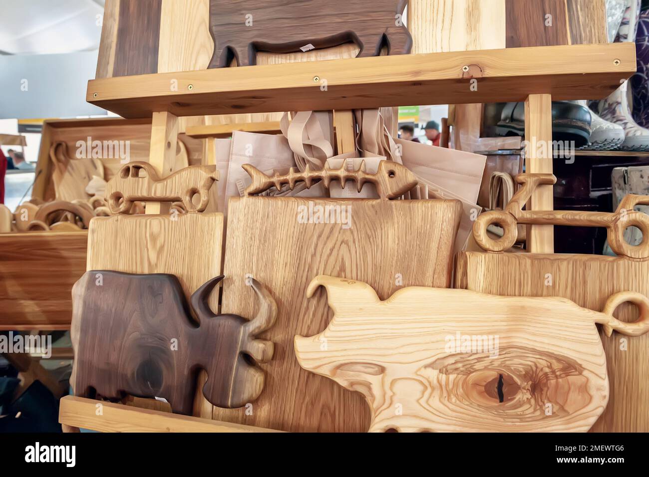 Handicrafts made of wood at the folk art fair. Cutting boards from different types of wood in