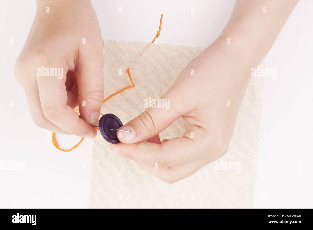 Child sewing on a button Stock Photo - Alamy
