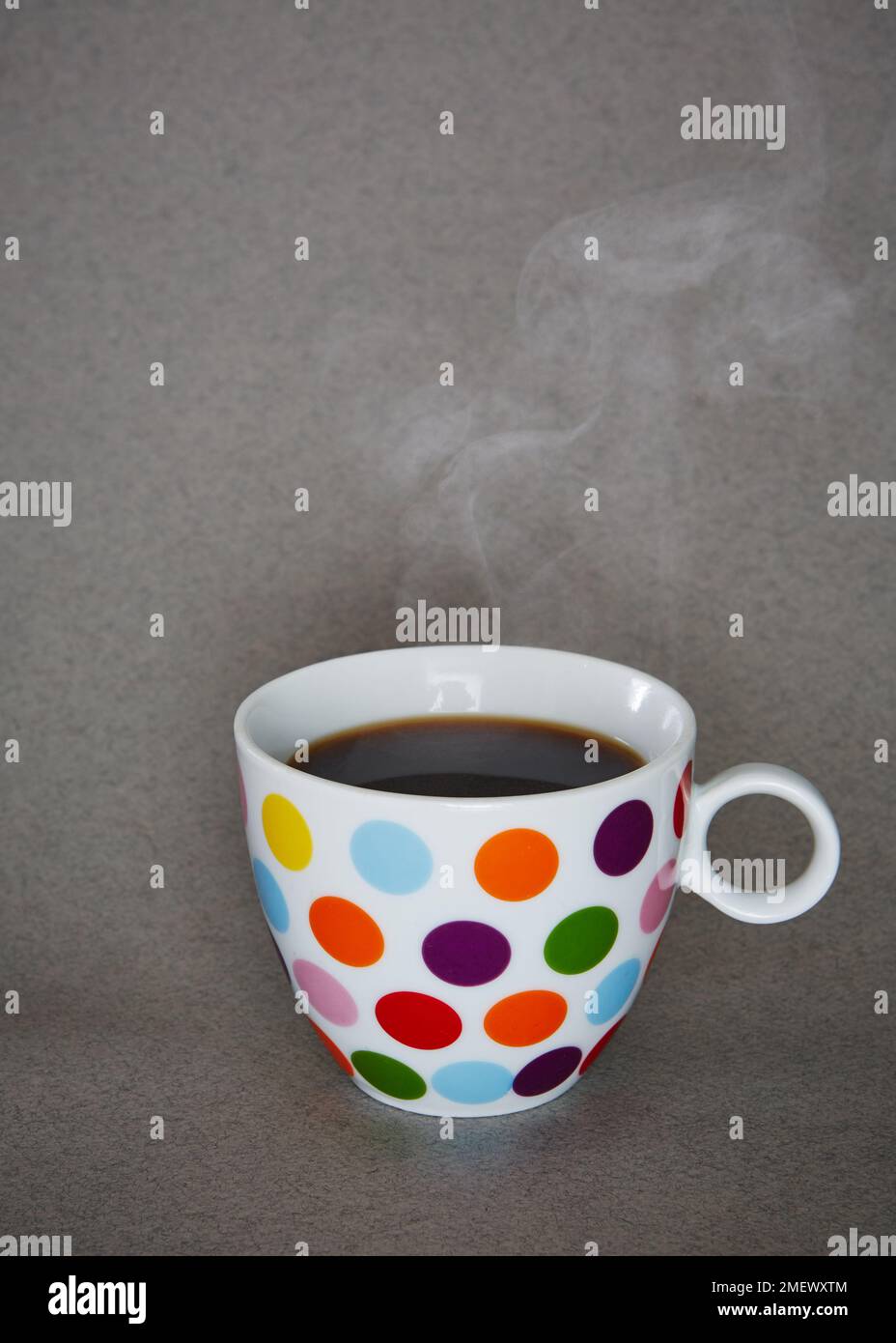 Spotty mug of a hot drink steaming Stock Photo