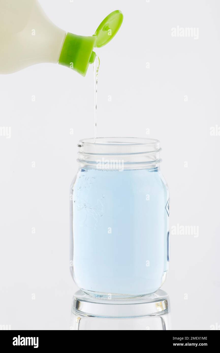 Washing up liquid being poured into a glass jar full of water Stock Photo -  Alamy