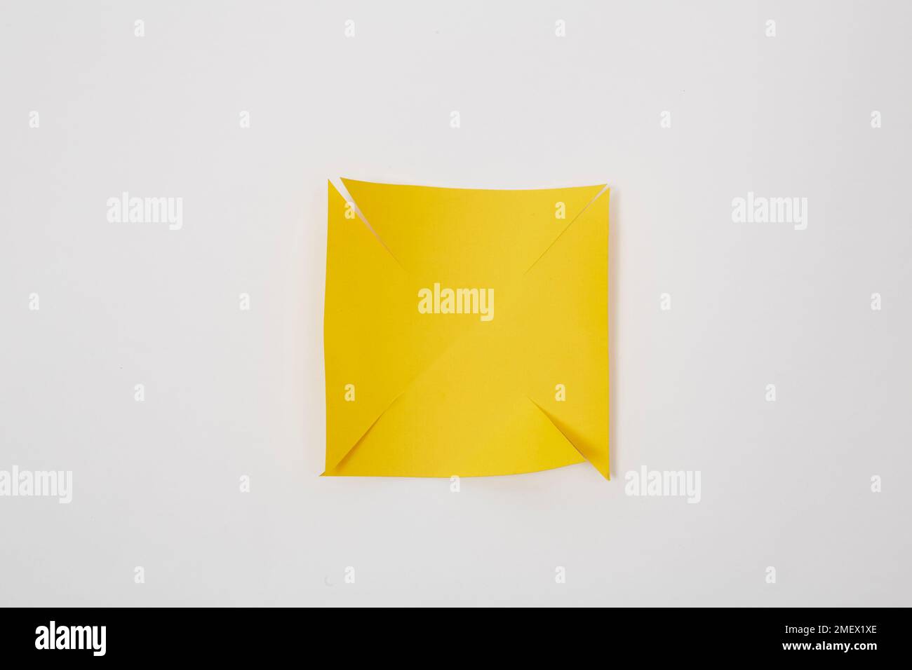 Square of yellow paper being shaped into a windmill Stock Photo Alamy