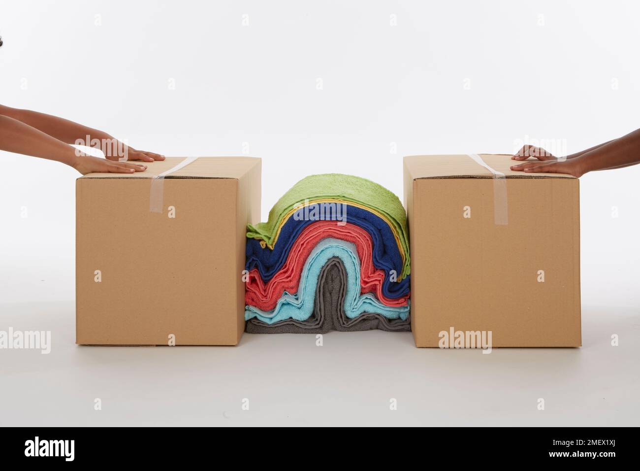 Creating a fold mountain by pressing together a pile of blankets between two boxes Stock Photo