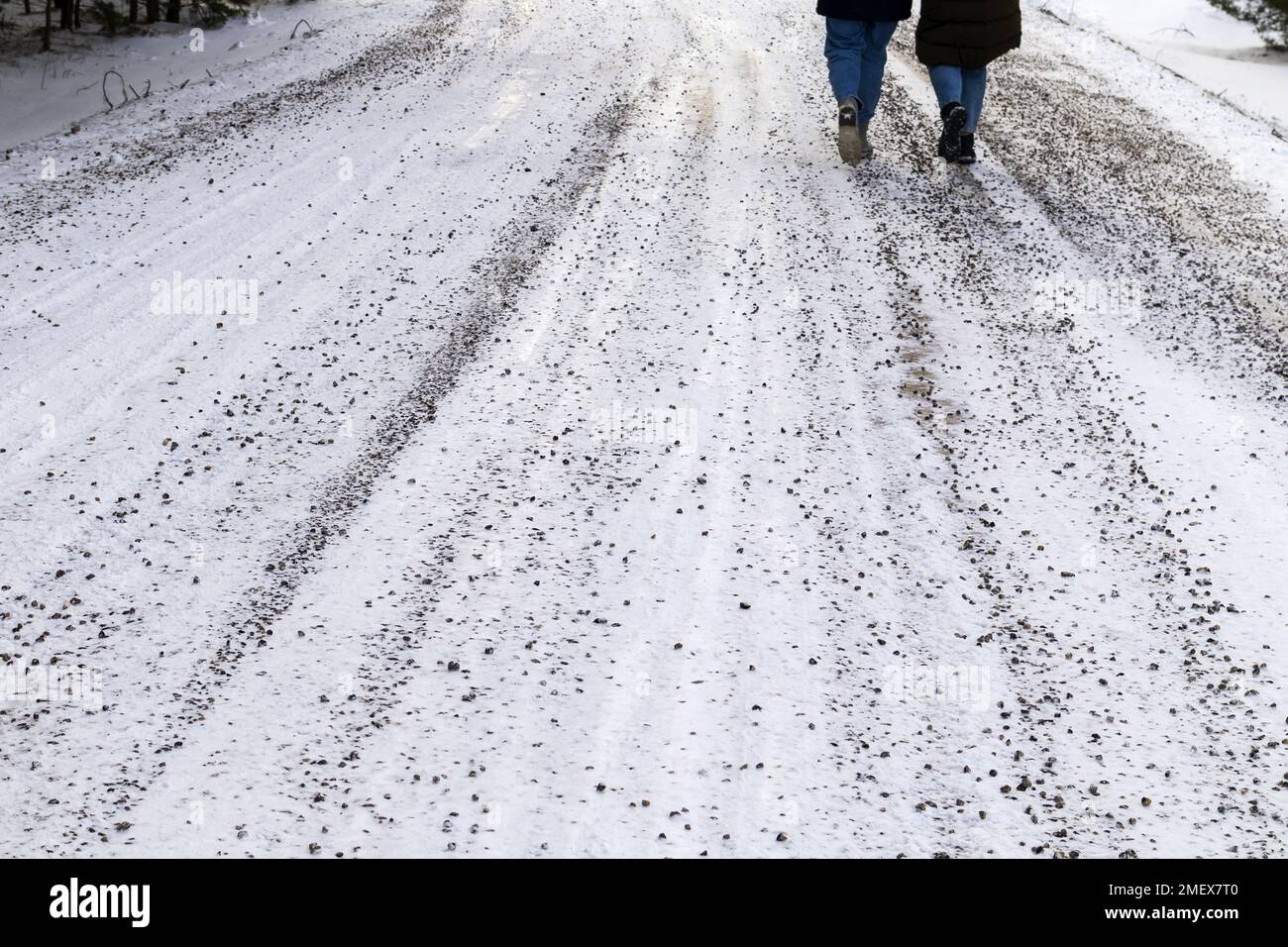 A sandy, gravel road with white snow and people legs Stock Photo - Alamy