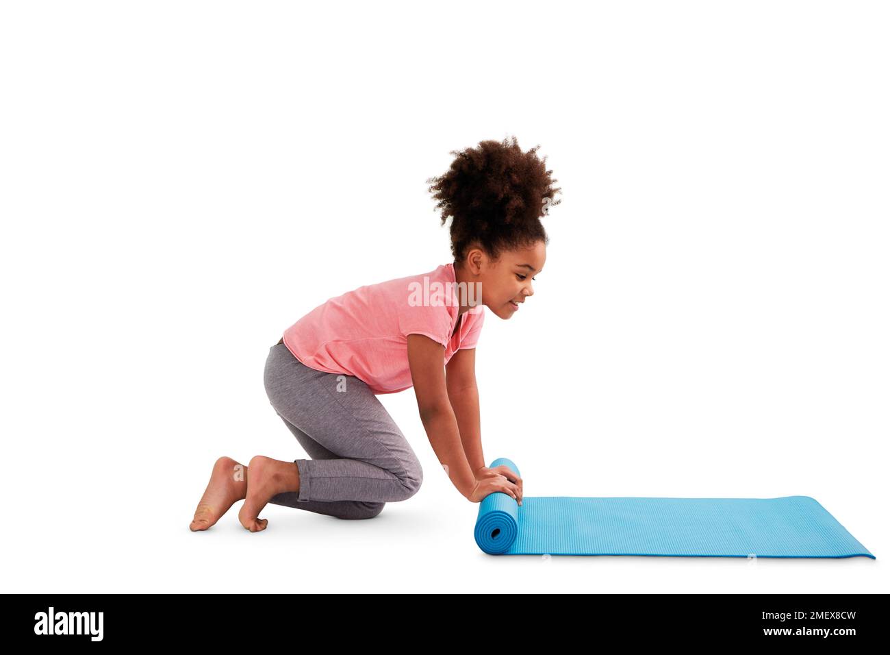 Girl rolling yoga mat. Stock Photo