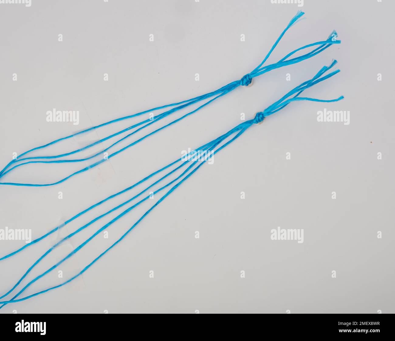 Blue string tied in knot Stock Photo - Alamy