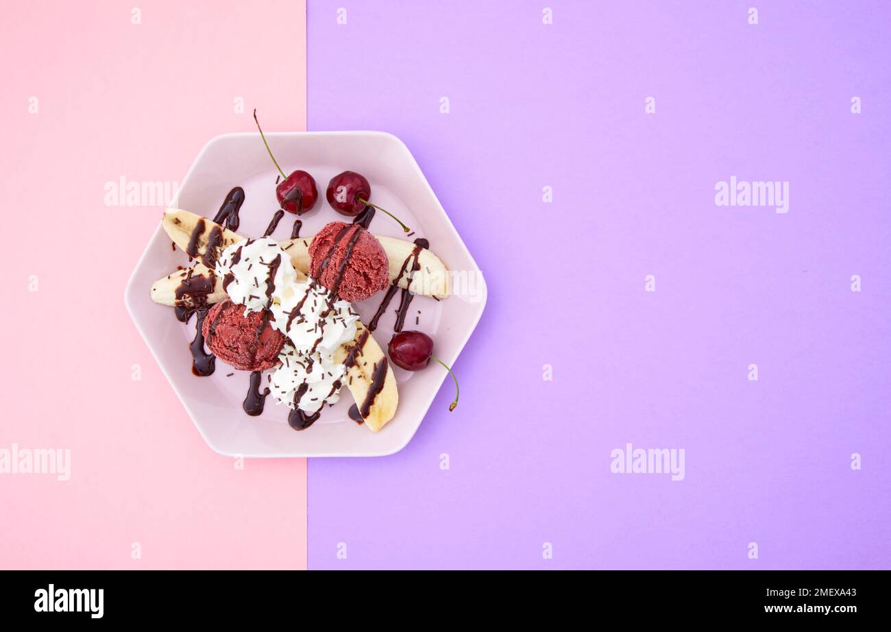 Banana split with cherry ice cream and whipped cream, overhead Stock Photo
