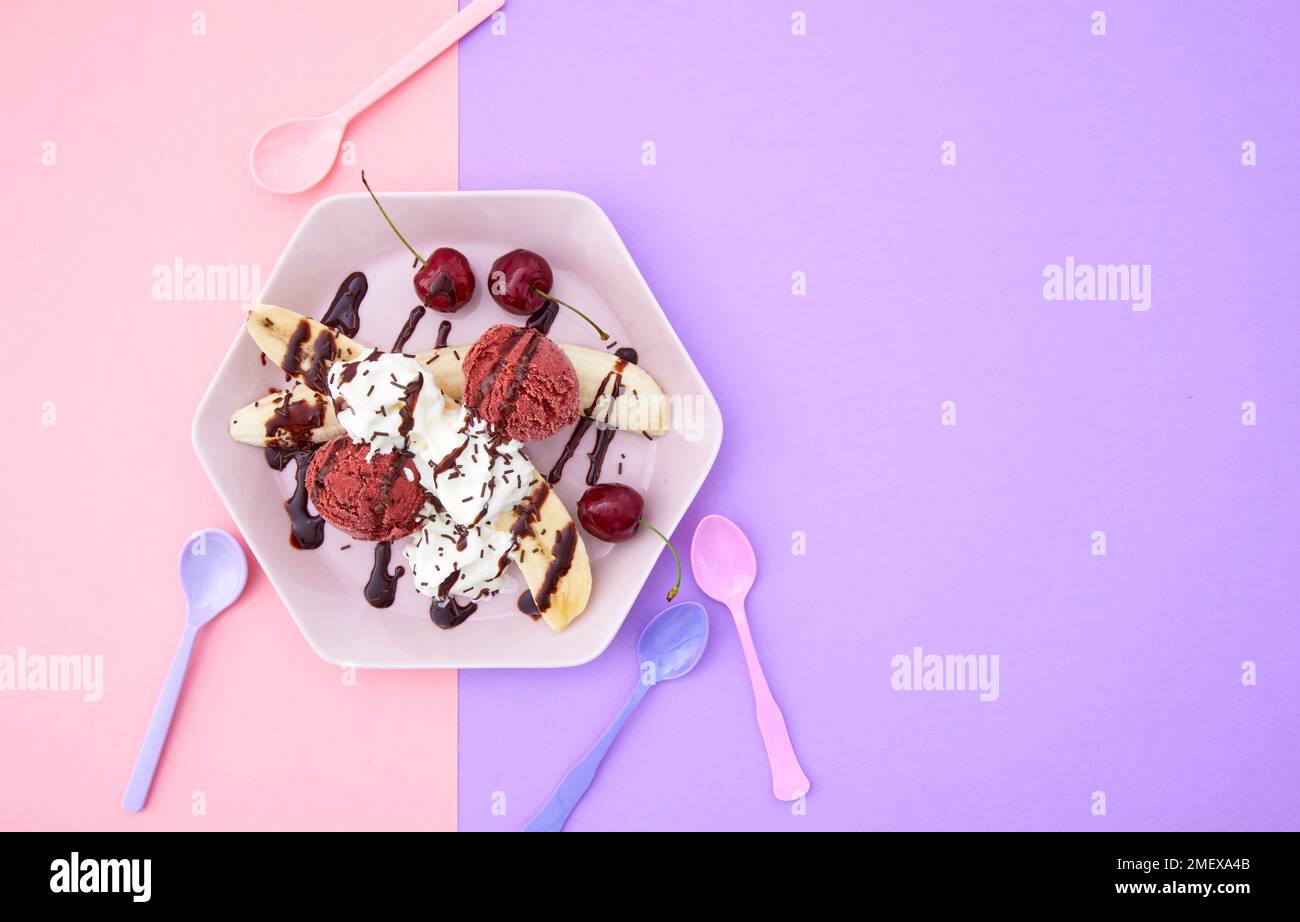 Banana split with cherry ice cream and whipped cream, overhead Stock Photo