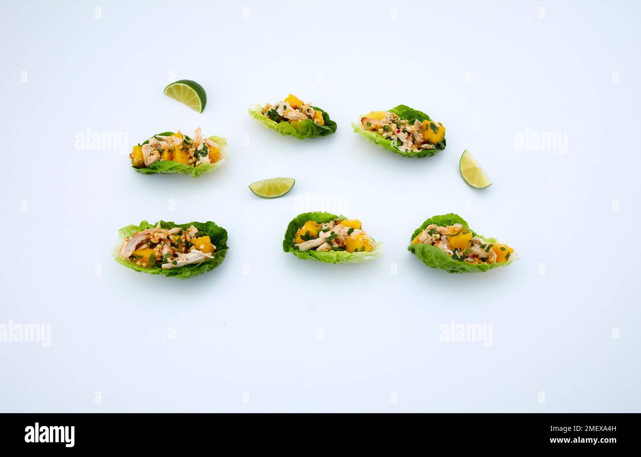 Chicken and mango lettuce boats on white background Stock Photo