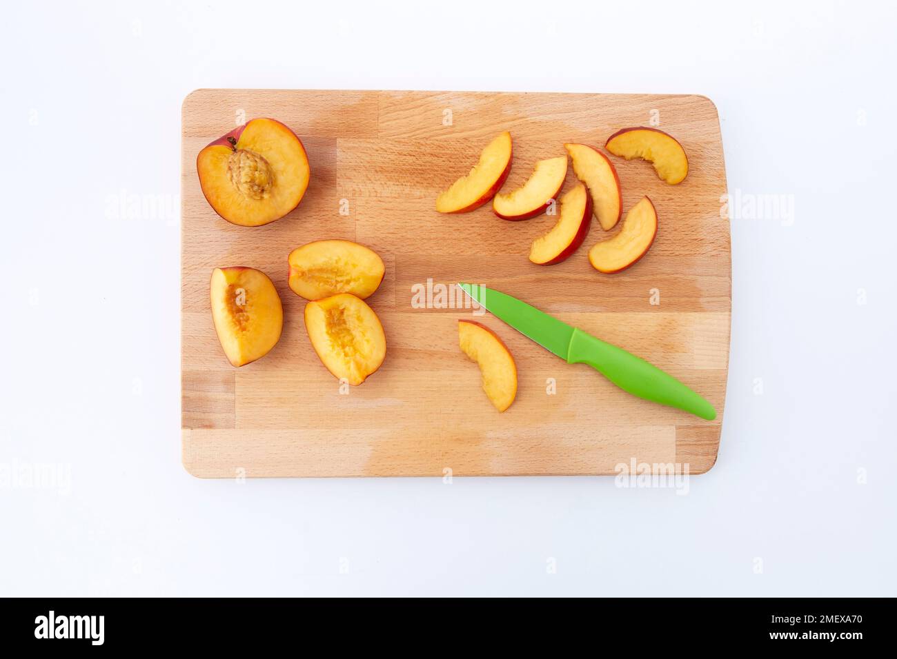 Nectarine and ricotta pancake pinwheels - Step 1 - Cut nectarine slices on chopping board Stock Photo