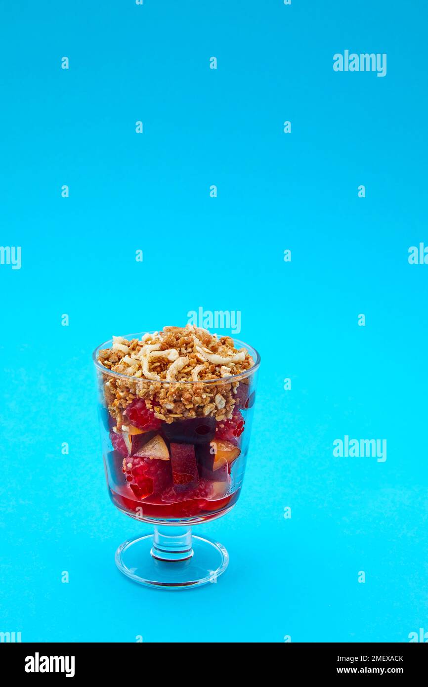 Plum and Raspberry crumble on blue background Stock Photo