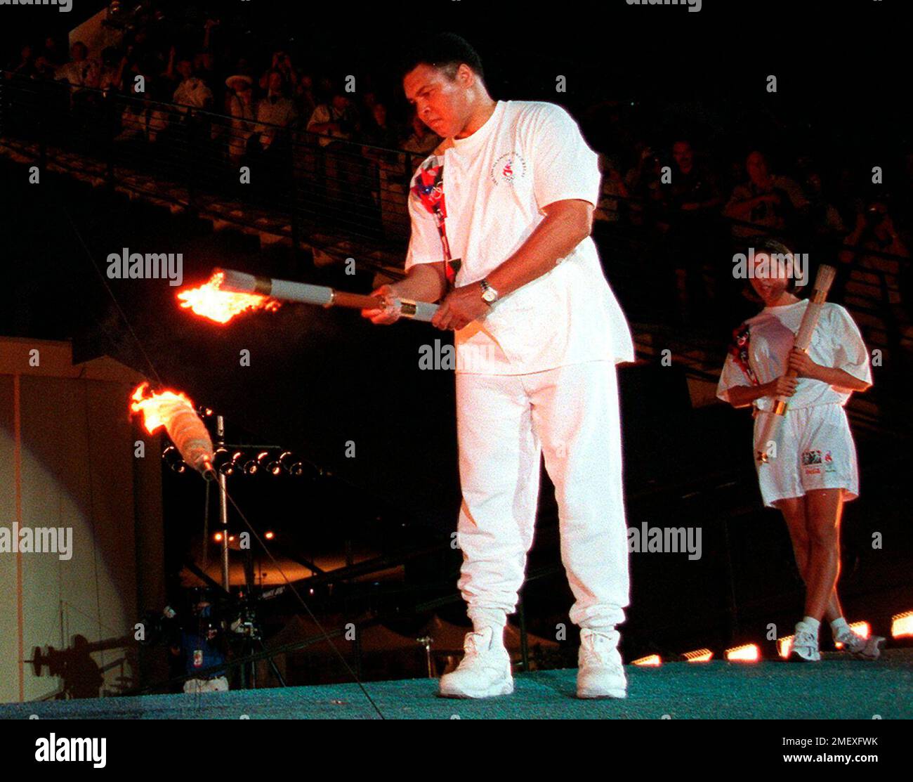 Boxing legend Muhammed Ali lights the Olympic flame, as American