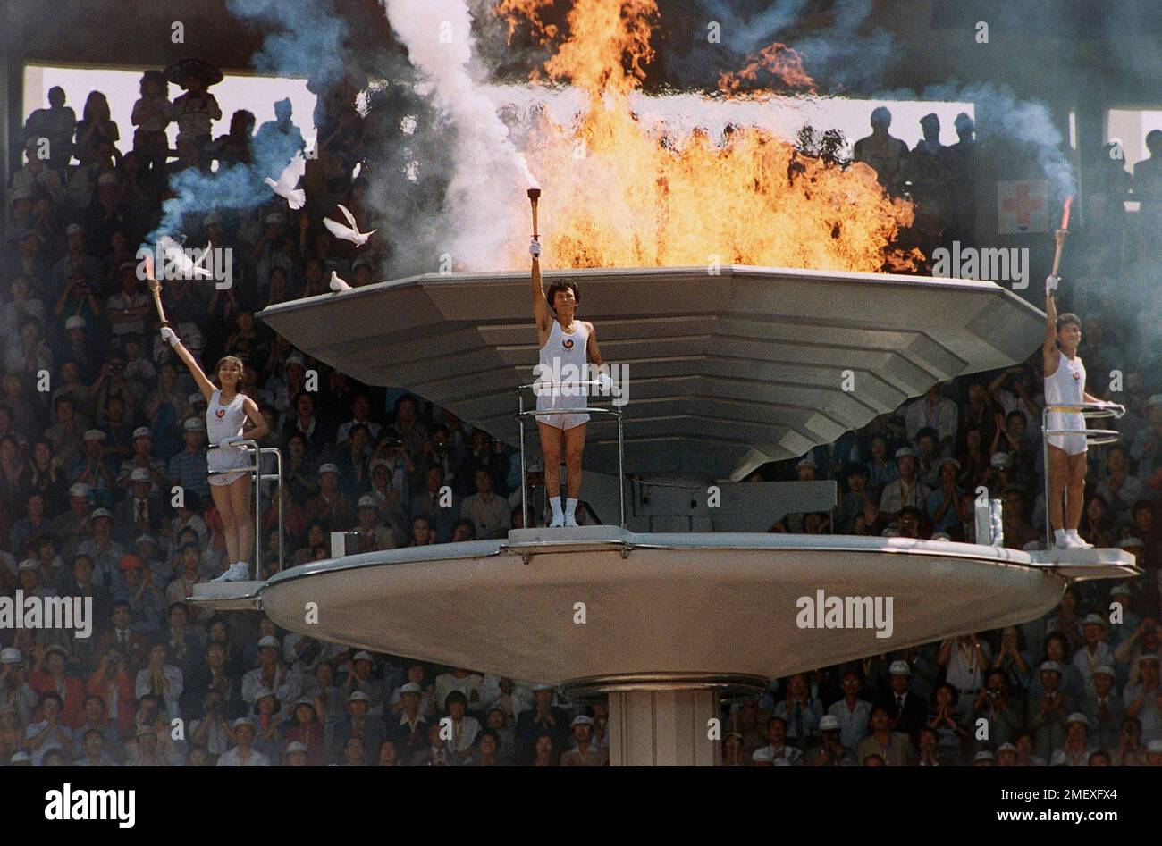 Pigeons fly around as the Olympic torch is lit during opening ...
