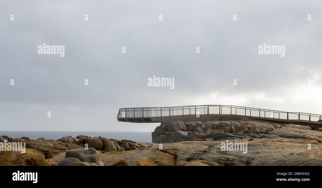 a desolate scene in dreary weather shows the cantilevered viewing platform at The Gap in Torndirrup NP on the south coast of Western Australia Stock Photo