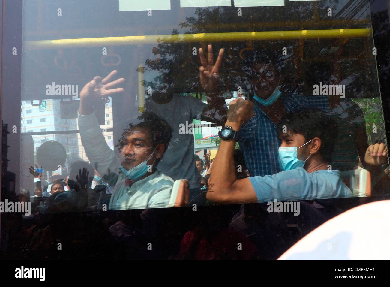 Arrested protesters flash the three-fingered salute while onboard a bus  that is getting out of Insein prison and will transport them to an  undisclosed location Wednesday, March 24, 2021 in Yangon, Myanmar. (